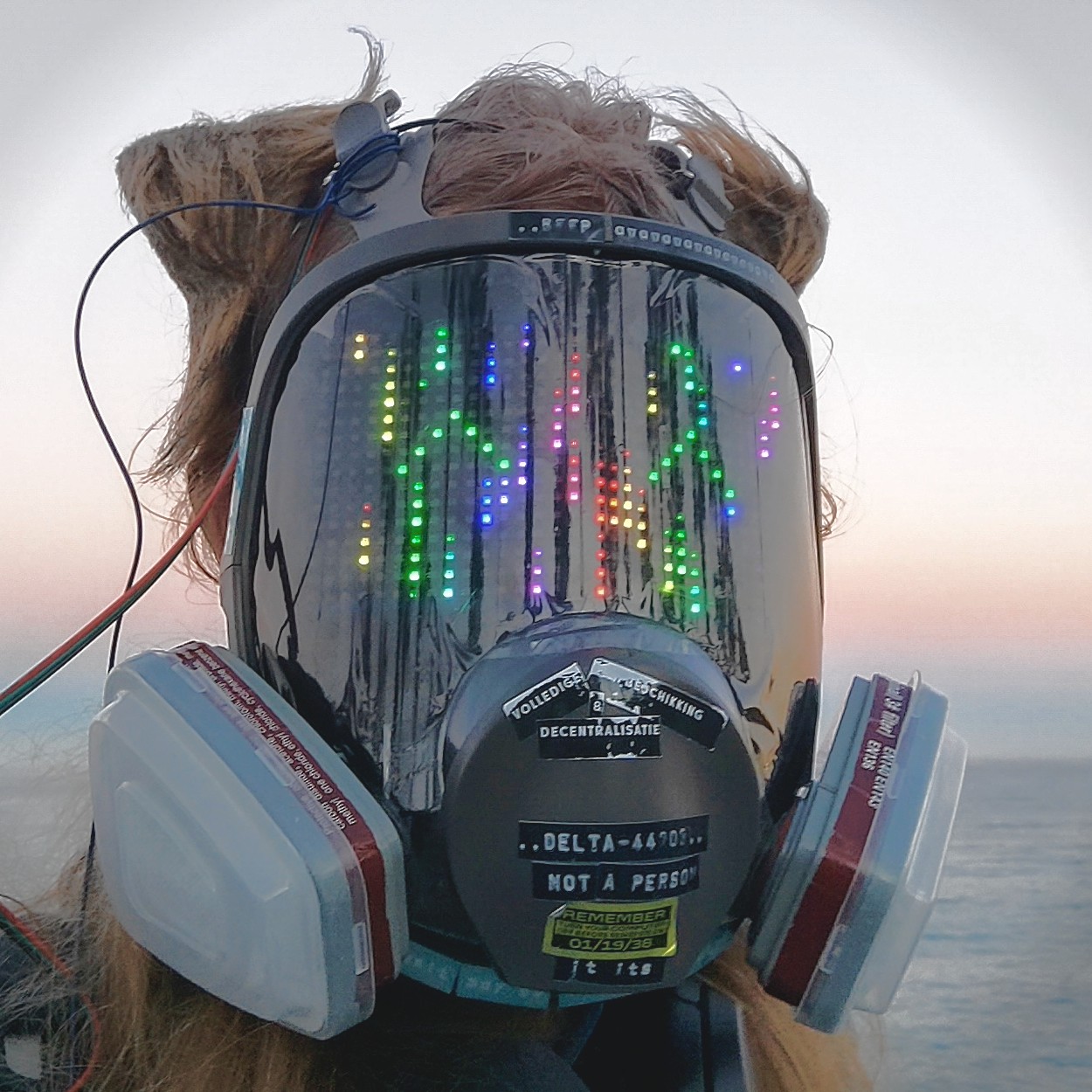 Δ-44203 before the ocean around sunset. Its visor displays a happy expression.