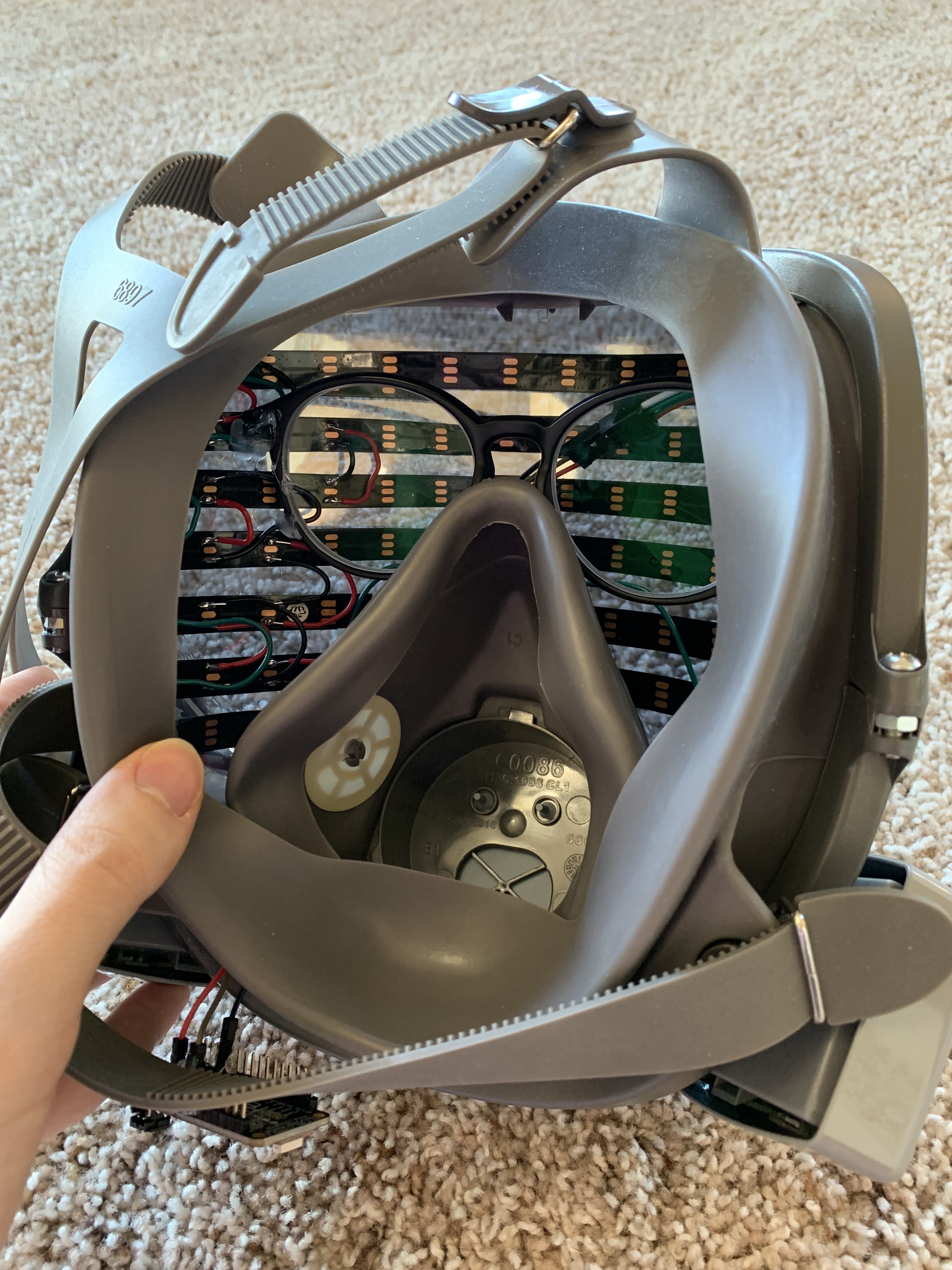 The inside of my LED respirator mask, showing the LED strips and a pair of glasses glued inside.